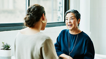 A woman chats with a colleague in an office