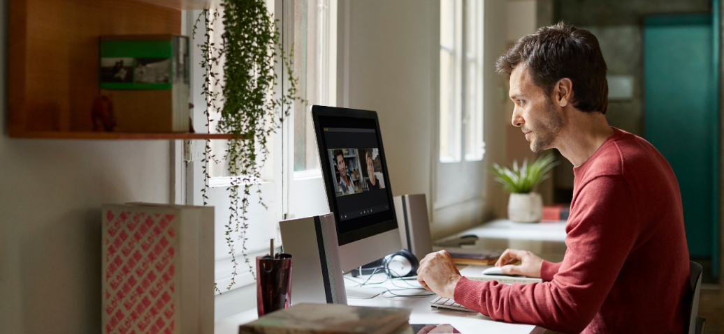 Side view of man using computer at table while working from home.